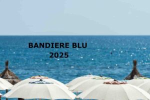 mare e ombrelloni, sritta baldiere blu 2025