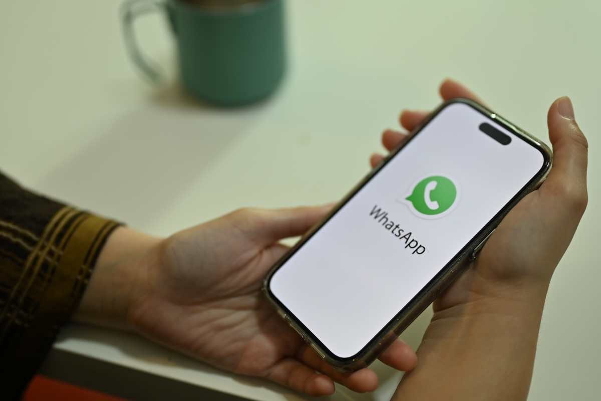 persona con cellualre in mano con whatsapp