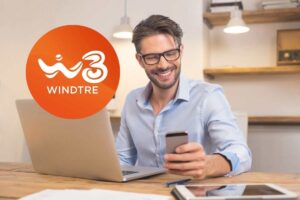 ragazzo sorride guardando lo smartphone e nel cerchietto il logo di wind tre